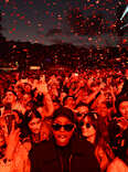 : Festival crowd on day 1 of Way Out West Festival 2023 under red light and confetti.