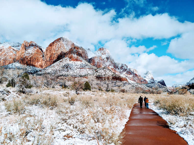 hikers ascending a snowy trail at zion national park 